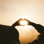 silhouette of hands forming heart shape