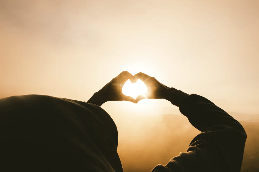 silhouette of hands forming heart shape