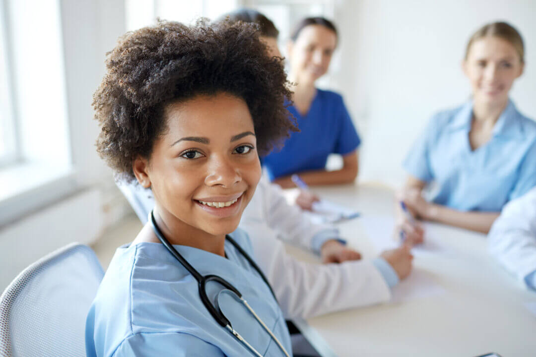 Student nurses sitting at table smiling