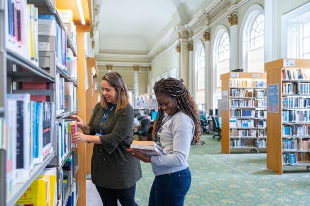 Two female students in library