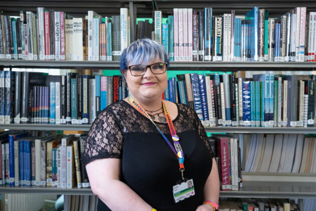 Bobby standing in front of library shelves of books